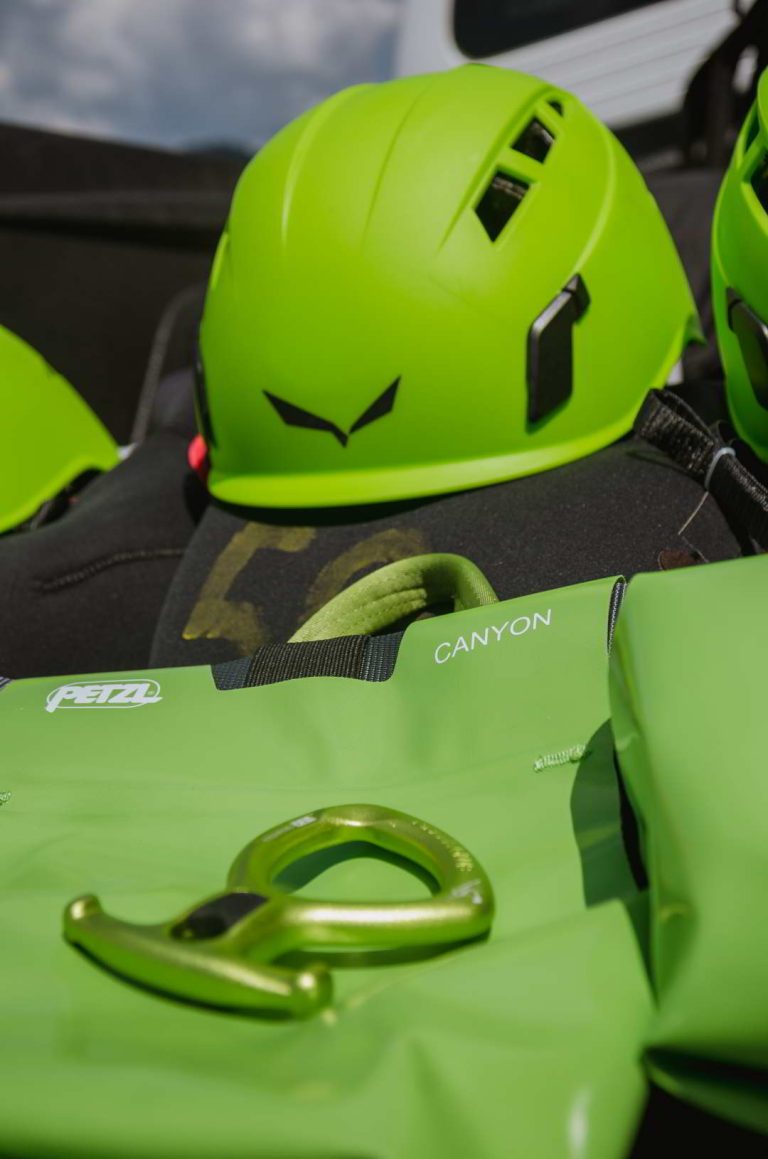 Green helmet, figure eight, harness, and black neoprene wetsuits.