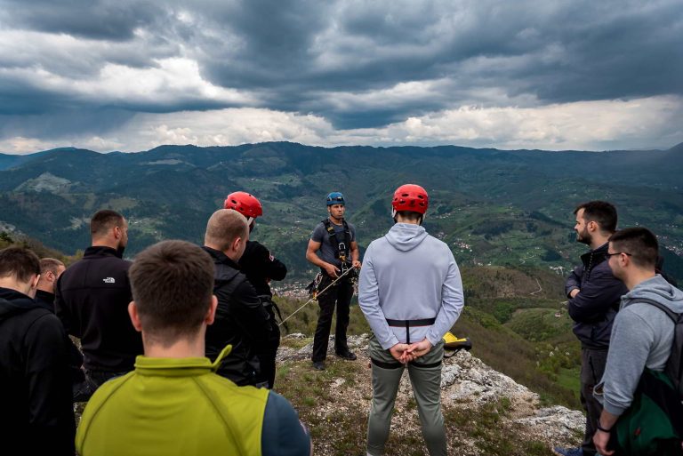 Grupa ljudi sa šlemovima na glavama u prirodnom okruženju
