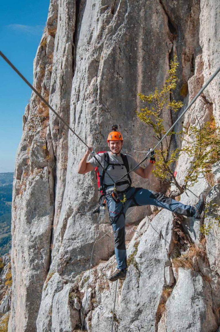 A man crosses a tightrope between two cliffs