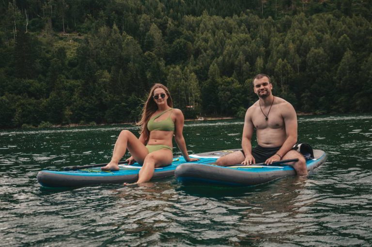 The boy and the girl are sitting on SUP boards