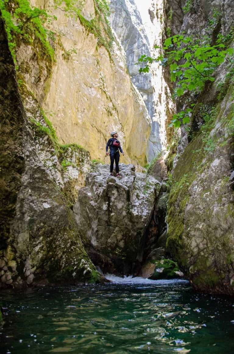 Muškarac stoji na steni iznad vode, sprema se za skok