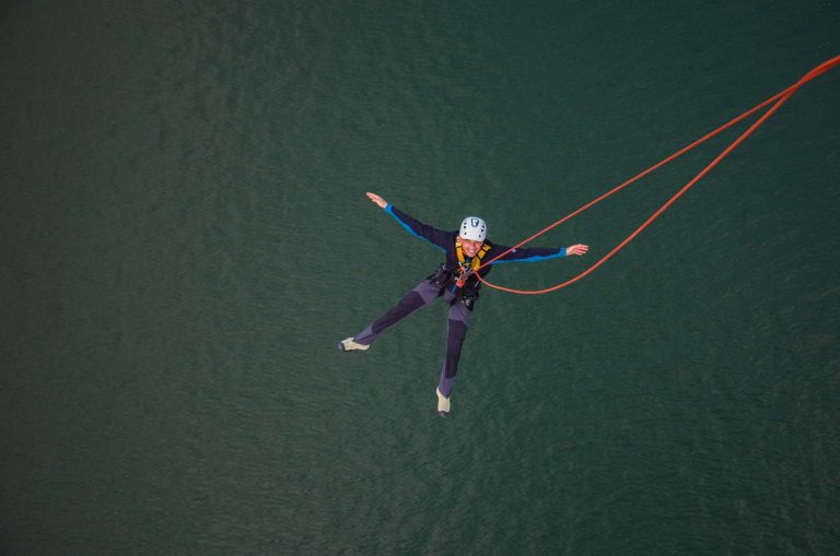 A man is flying above the lake.