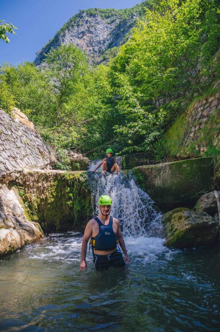 Otac i sin stoje u reci pored vodopada Kratovske reke